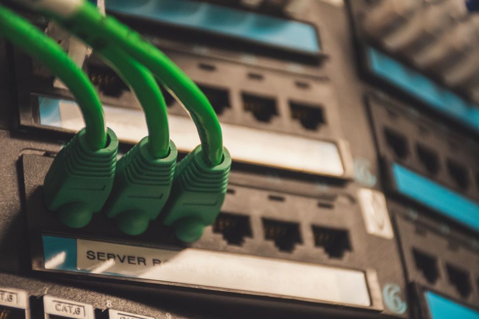 Primer plano de cables de red verdes conectados a puertos de servidor
